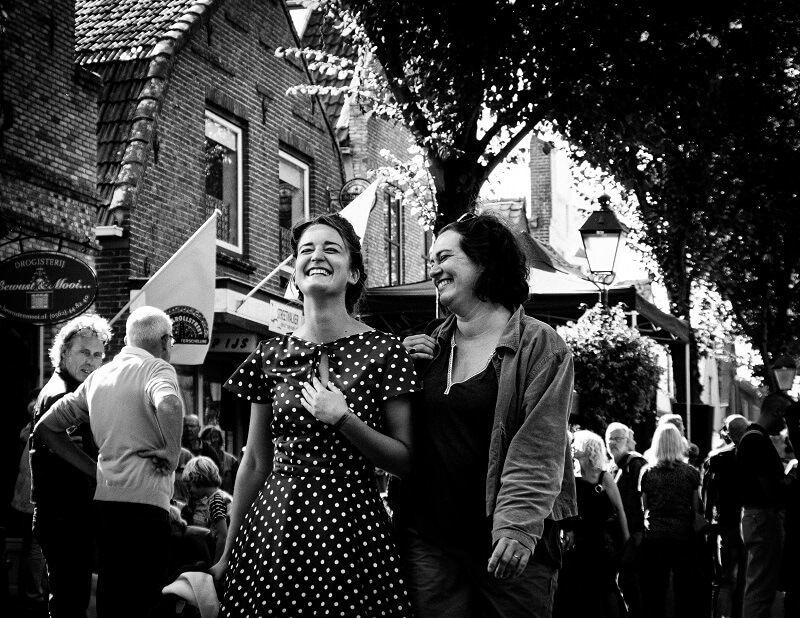 Twee lachende dames tijdens het Rock and Roll Street Terschelling festival in september 2016.