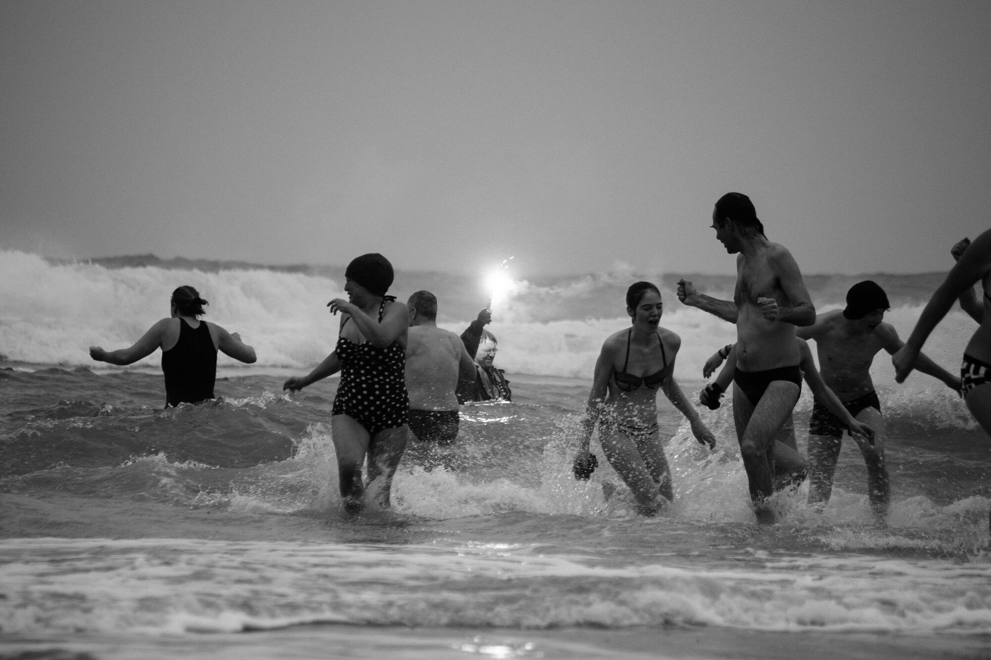 Deelnemers van de Nieuwjaarsduik Terschelling in het water bij Midsland aan Zee.