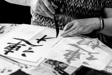 Japanse Kalligrafie workshop deelnemer maakt een teken met een kwast.