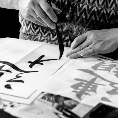 Japanse Kalligrafie workshop deelnemer maakt een teken met een kwast.