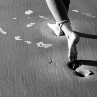 Yvon laat voetafdrukken na in het zand