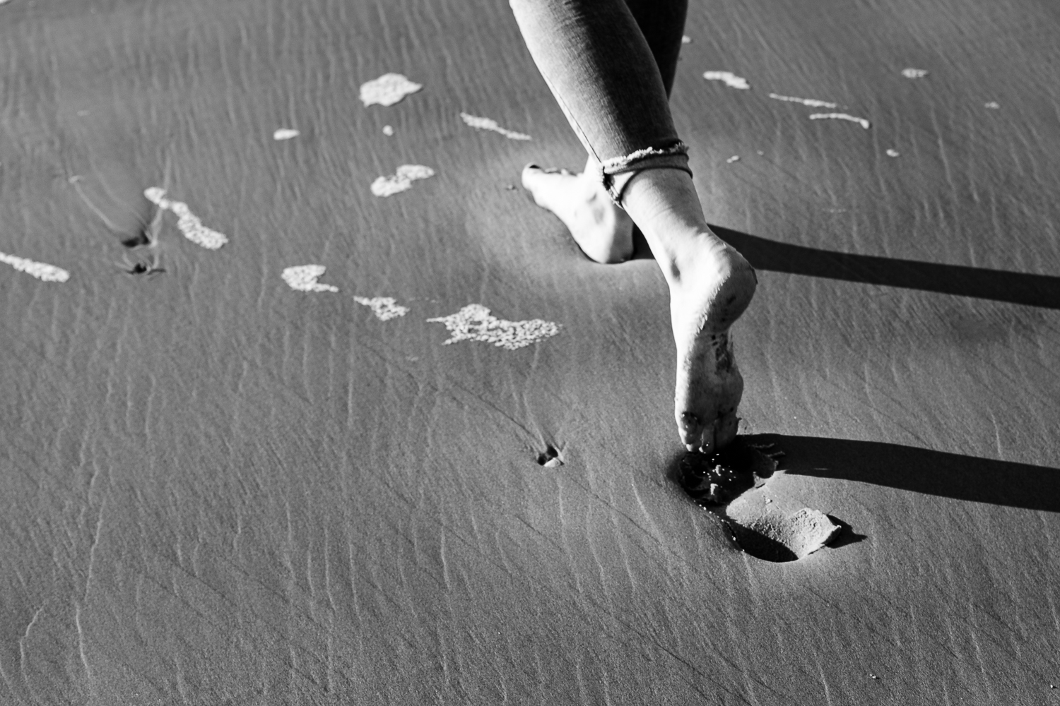 Yvon laat voetafdrukken na in het zand