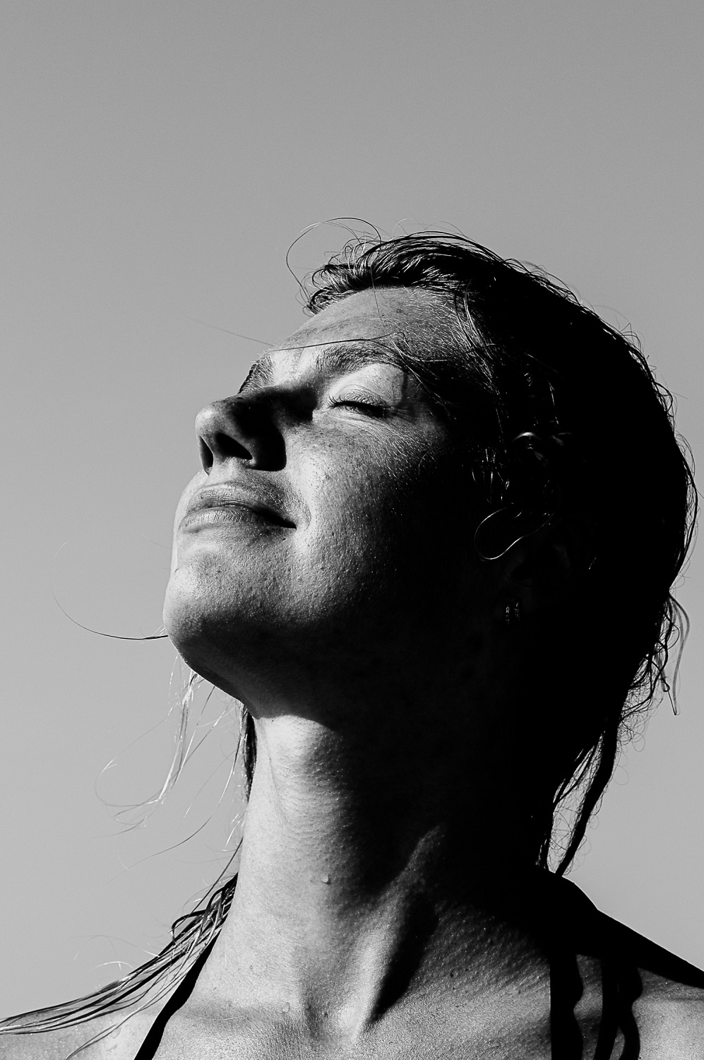 Close-up portret van Ezra Goudzwaard die met haar ogen dicht geniet van de zon,